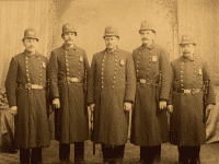 Five men in old-fashioned constable uniforms with billy clubs.