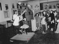 One child sitting in a dentist's chair with a group of children in the background